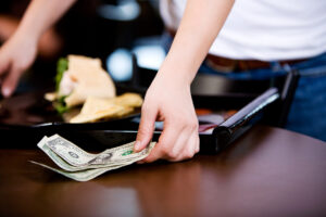 How giving big tips at restaurants became so common in America?
